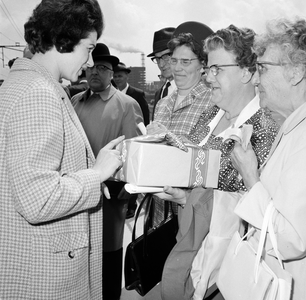 171877 Afbeelding van de overhandiging van een doos met gratis treinkaartjes door N.S.-ambassadrice Jeanne Vollemans ...